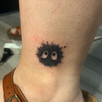 a small mushroom tattoo on the ankle of a woman